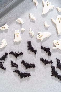 Filling Halloween silicone mold with melted chocolate to make chocolate decor for pretzels.
