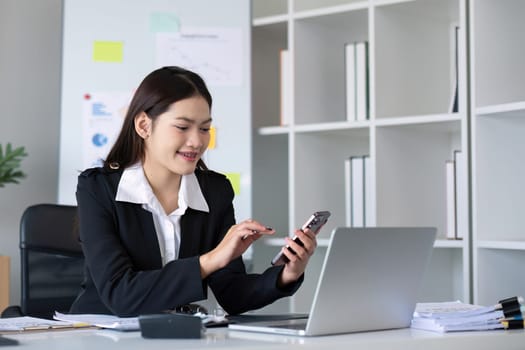 Happy asian business woman have the joy of talking on the smartphone, tablet and laptop on the modern office.