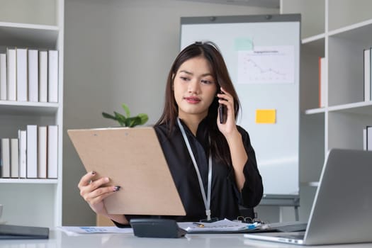 Happy asian business woman have the joy of talking on the smartphone, tablet and laptop on the modern office.