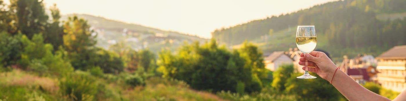 A woman drinks wine against the backdrop of mountains. Selective focus. travel.