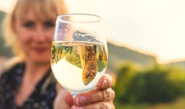 A woman drinks wine against the backdrop of mountains. Selective focus. travel.