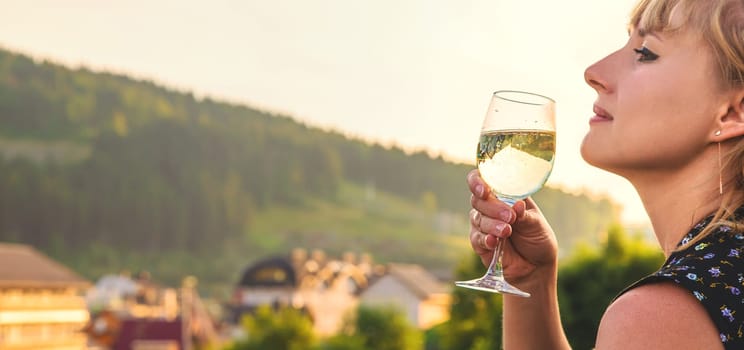A woman drinks wine against the backdrop of mountains. Selective focus. travel.