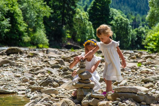 Children throw stones into the river. Selective focus. Kid.