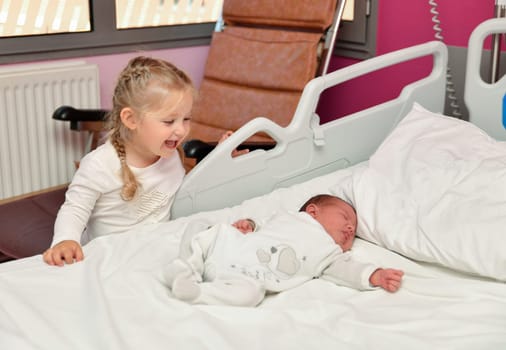 The first acquaintance between a sister and a newborn baby in the hospital ward