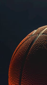 basketball with a warm, glowing light accentuating its textured surface. The black backdrop provides a stark contrast, highlighting the intricate details, distinctive pattern of the ball's exterior