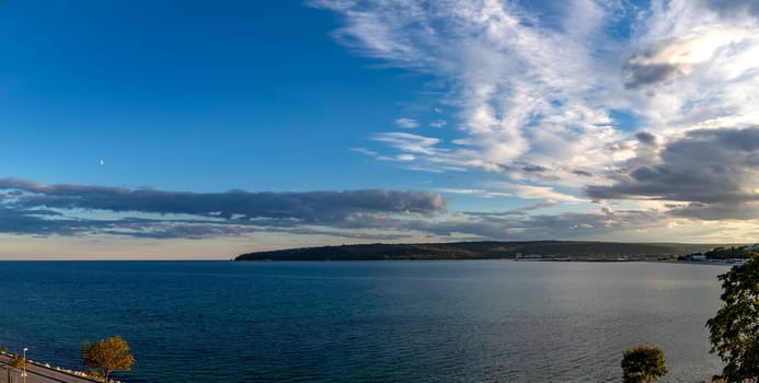 Panoramic view at sea bay and cloudy sunset sky.