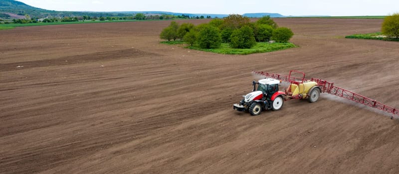 Panoramic ?erial view of field and tractor spraying grain