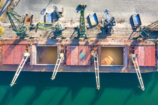 Top view from a drone of a large ship loading grain for export. Water transport 