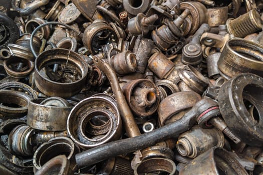 rusted steel scrap pile of used car parts and pieces - full-frame closeup background and texture