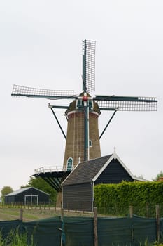 Windmill in a Dutch village. Vertical frame.