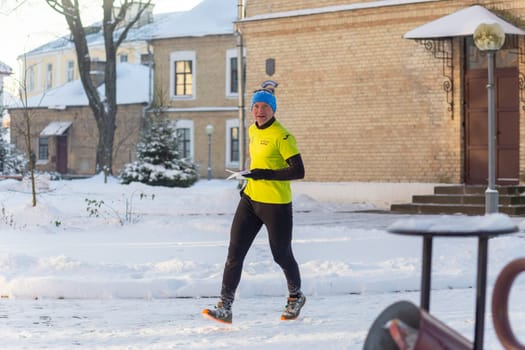 Grodno, Belarus - January 03, 2024: Young man participates in winter orienteering training in urban conditions. Outdoor orienteering check point activity