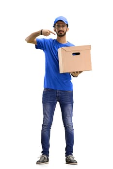 A male deliveryman, on a white background, in full height, points to the box.