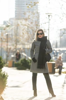 Beautiful girl in a coat and scarf and black glasses. High quality photo