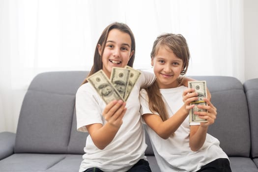 Portrait of two business children with US Dollars as symbol of bribe in an envelope. High quality photo