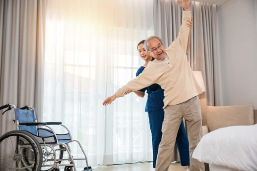 Old senior man enjoys training with physiotherapist for outstretched arms at home, Asian physical therapist patient nursing helping elderly exercising arm stretch, Rehabilitation of disabled concept