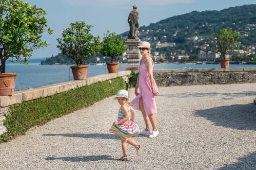 Mother and daughter dancing on the island of Isola Bella on Lake Maggiore in Italy