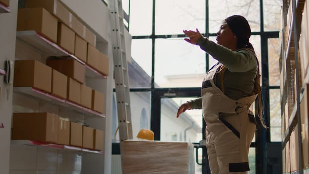 Manager in warehouse using AR holographic technology to visualize how to best stash parcels on shelves to make room for more. Supervisor in distribution center uses augmented reality