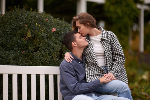 lovely young couple kissing outdoors in autumn. Loving couple walking in nature. Autumn mood. Happy man and woman hugging and kissing in autumn. Love. Fashionable couple outdoors. Fashion, people and lifestyle. Stylish couple in autumn outfit.