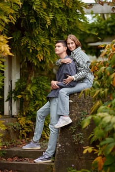 Joyful Autumn Embrace: Cute Lovers Strolling in the Park. Young Cute Female Hugs Boyfriend. In Autumn Outdoor. Lovers Walking in Park. Attractive Funny Couple. Lovestory in Forest. Man and Woman. Cute Lovers in the Park. Family Concept. Happy Couple.