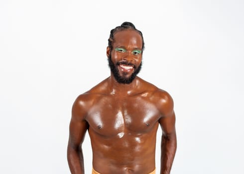 Positive african-american bearded gay man with bright makeup isolated on white background. Exudes sense of pride and individuality. Diversity power of personality.