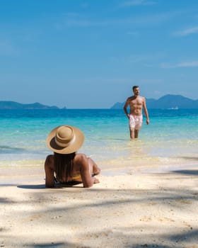 Koh Wai Island Trat Thailand near Koh Chang Trat. A young couple of men and women on a tropical beach during a luxury vacation in Thailand relaxing on the beach with turqouse colored ocean