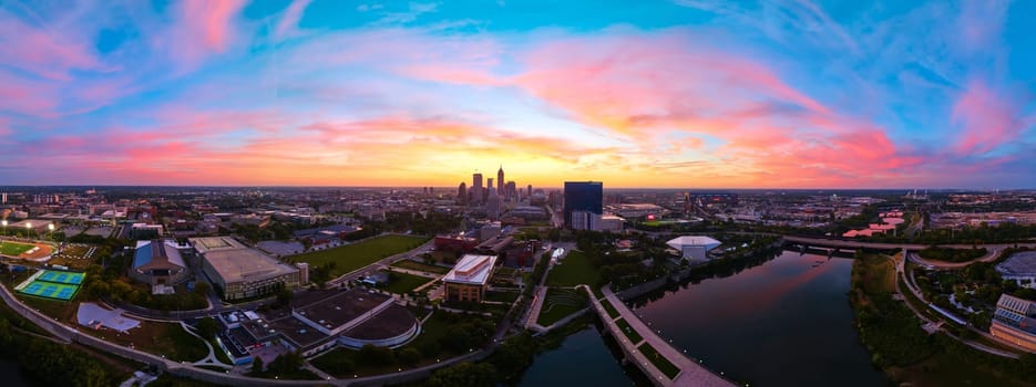 Stunning 2023 aerial panorama of Indianapolis downtown skyline at sunrise, captured by DJI Mavic 3 drone, highlighting the golden hour transitioning to a vibrant pink sky