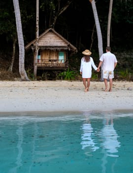 Koh Wai Island Trat Thailand near Koh Chang. wooden bamboo hut bungalow on the beach. a young couple of men and woman on a tropical Island in Thailand, soft out of focus, focus on the ocean