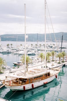 Luxury sailing yacht moored at the pier against the background of motor yachts. High quality photo