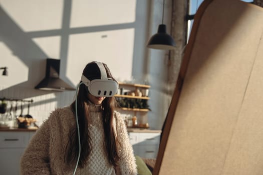 In the daylight, a lively young woman wears a virtual reality headset before the mirror. High quality photo