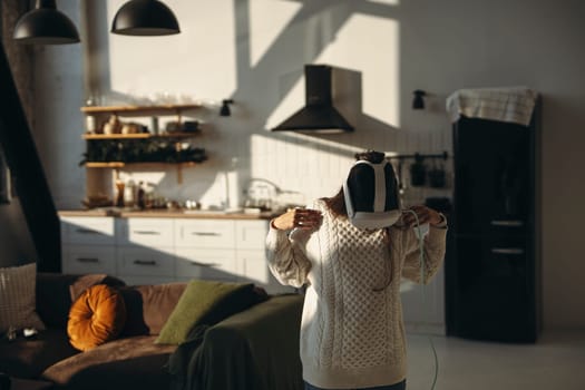 In the comfort of her apartment, a stunning young lady plays an online game with a VR headset. High quality photo