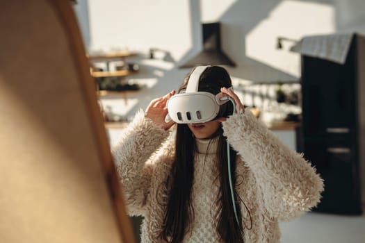 On a sunny day, a bright young woman experiences virtual reality in front of the mirror. High quality photo