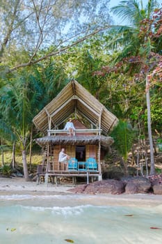 Koh Wai Island Trat Thailand is a tinny tropical Island near Koh Chang. wooden bamboo hut bungalow on the beach. a young couple of men and woman at a bamboo hut on a tropical Island in Thailand
