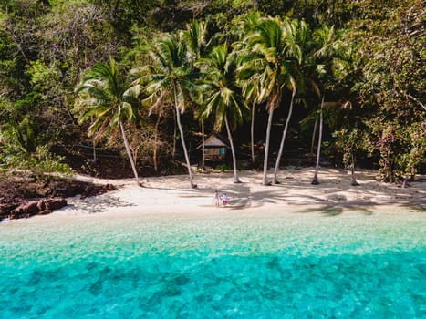 Koh Wai Island Trat Thailand, wooden bamboo hut bungalow on the beach. a young couple of men and woman on a tropical Island in Thailand with palm trees on the beach and turqouse colored ocean