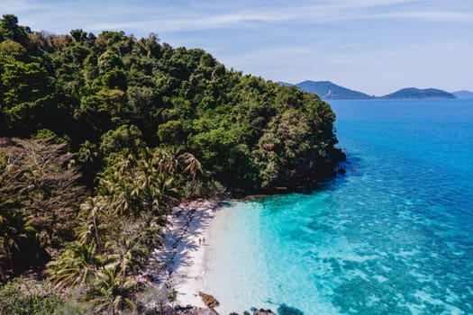 Drone aerial view at Koh Wai Island Trat Thailand near Koh Chang. a young couple of men and women on a tropical beach during a luxury vacation in Thailand walking at the beach