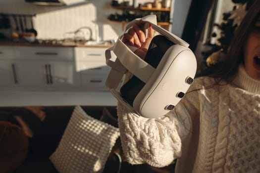A bright young woman received a virtual reality headset as a Christmas gift. High quality photo