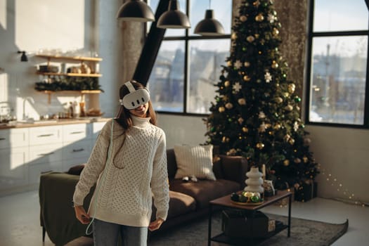 A young woman, immersed in an online game, wears a virtual reality headset at home. High quality photo