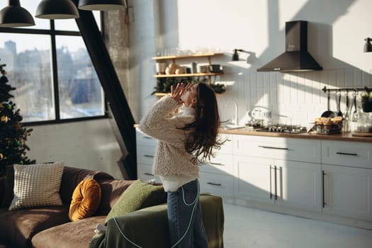 An active young woman in a virtual reality headset in a sunlit apartment. High quality photo