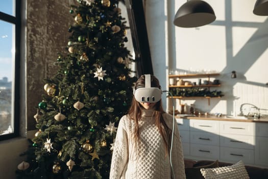 In the glow of a winter morning, a bright young woman explores virtual reality with a headset. High quality photo