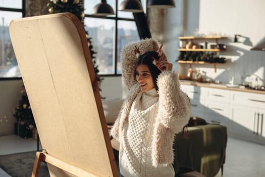 Getting ready for a Christmas party, a lively young lady styles her hair in the apartment mirror. High quality photo