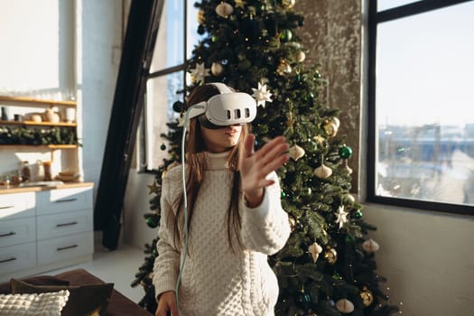 The portrait captures a beautiful girl wearing a virtual reality headset amidst a Christmas tree. High quality photo