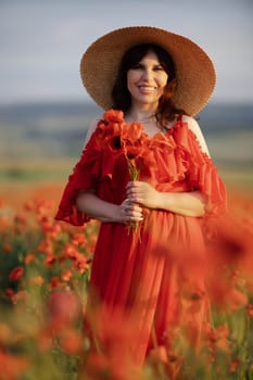 Woman poppy field red dress hat. Happy woman in a long red dress in a beautiful large poppy field. Blond stands with her back posing on a large field of red poppies