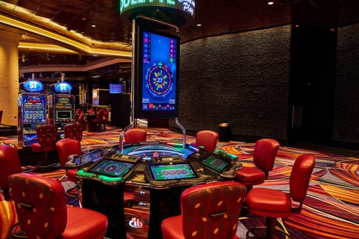 Vibrant electronic roulette table in a luxurious Bahamas casino, showcasing a lively gaming floor with bright slot machines