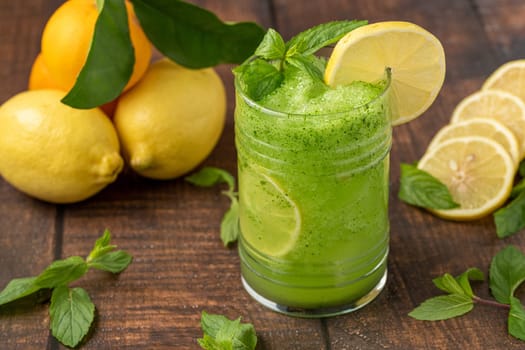 Lemonade with ice and mint in glass glass on wooden table