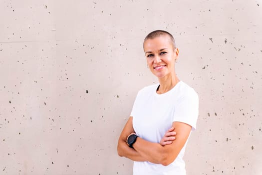young woman with short hair smiling happy with arms crossed looking at camera, copy space for text