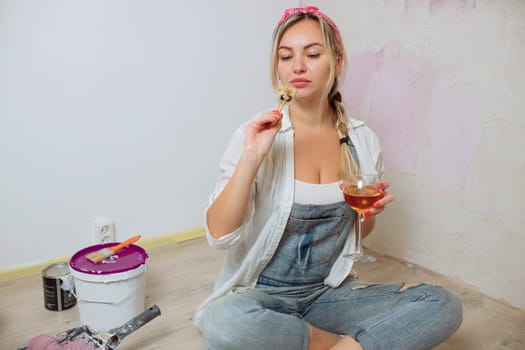 Sexy girl designer eats sushi on the construction site. painter has lunch after work. Concept interior design and room repair.