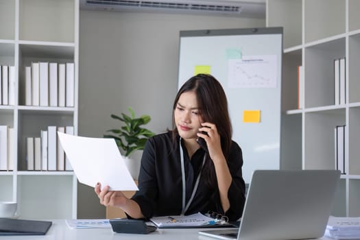 Happy asian business woman have the joy of talking on the smartphone, tablet and laptop on the modern office.