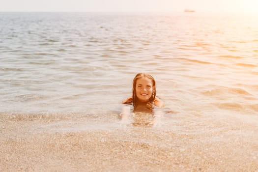 Woman travel sea. Young Happy woman in a long red dress posing on a beach near the sea on background of volcanic rocks, like in Iceland, sharing travel adventure journey