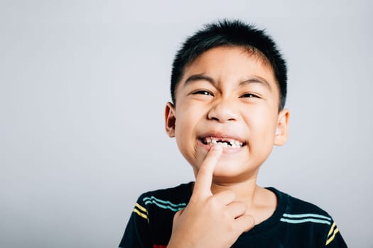 Six year old schoolboy happily points to growing molar gap. cheerful cute portrait child journey in losing primary baby teeth showcasing joy and dental care. teeth new gap dentist problems