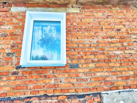 Front view of new plastic windows in old red brick wall. Abstract background, texture, pattern, copy space and place for text