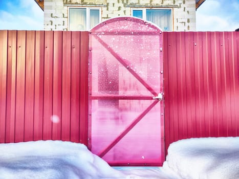 New gate, entrance to a private territory on a winter day and snow. Metallic texture and background. Fence